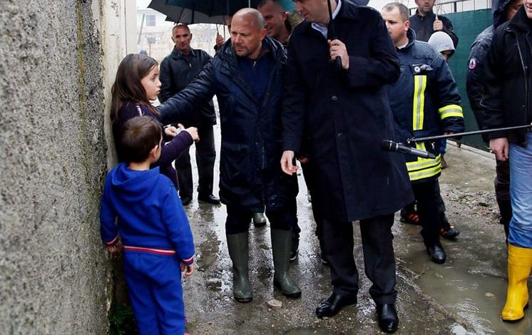 Fotoja që flet sa njëmijë fjalë: Fëmijët e Kamzës në shi dhe politika poshtë çadrës