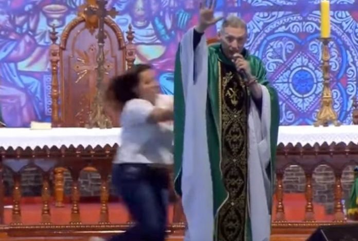 PO MBANTE MESHËN/ Prifti i ndodh e pabesueshmja nga gruaja dhe “fluturon” nga skena (VIDEO)
