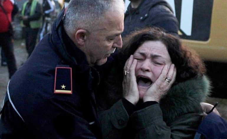 FOTO SA 1000 FJALË/ Efektivi i policisë ngushëllon një grua, të afërmit e së cilës janë bllokuar nën rrënoja