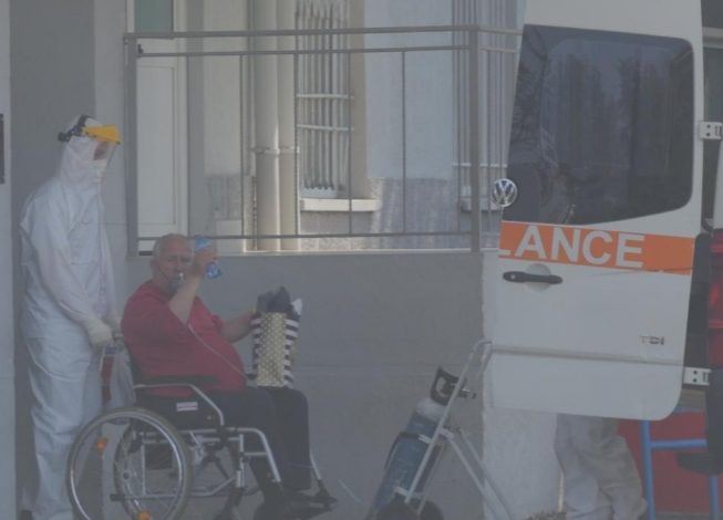 KORONAVIRUSI/ Me maskë oksigjeni dhe i ulur në karrocë, lë Infektivin si triumfator. Pacienti përshëndet me dorë familjarët