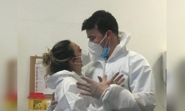TË MBULUAR ME VESHJE MBROJTËSE/ Çifti i infermierëve shqiptarë në Itali formojnë shqiponjën (FOTO)