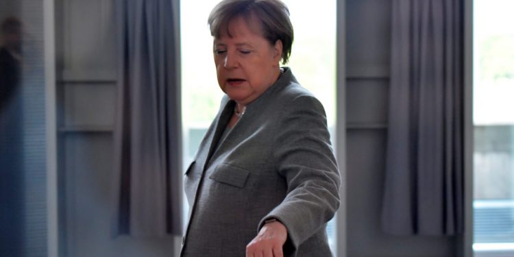 MESAZH I KODUAR PËR KANCELAREN MERKEL/ Një gur varri i rrethuar nga trëndafila të kuq dhe qirinj para zyrës