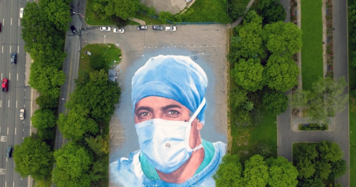 NDËRROI JETË NGA COVID-19/ Artisti pikturon portretin e mjekut në mes të parkut (FOTO)