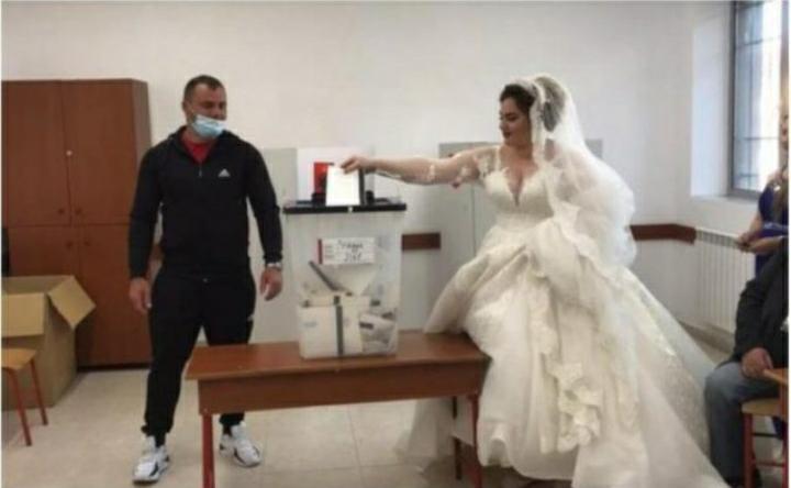 NDODH EDHE KJO/ Me fustan të bardhë, nusja në Kavajë shkon të votojë përpara dasmës