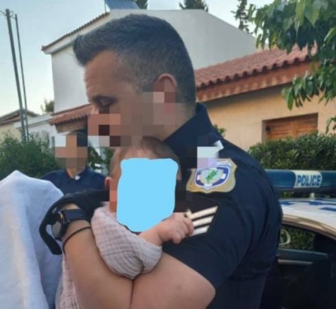 FOTO QË PËRLOTI BOTËN/ Shefi i policisë greke mban në duar foshnjën që i vranë nënën gjatë grabitjes tronditëse