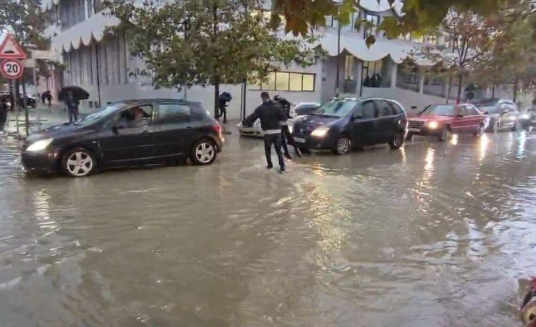 PAMJET/ Mbushen me ujë rrugët pranë stadiumit, prindërit marrin në krahë fëmijët për t’u kaluar rrugën