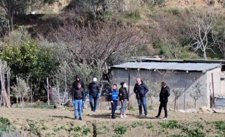 ME MASKË NË FYTYRË, E RRETHUAR NGA POLICËT/ Hygerta Meta rikthehet në vendin ku vrau dhe groposi të atin
