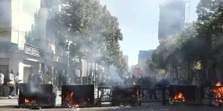 PROTESTA/ Rruga bllokohet me koshat e mbeturinave që u vihet flaka! Të rinjtë sulmojnë me gurë, Policia i zmbraps me gaz e ujë